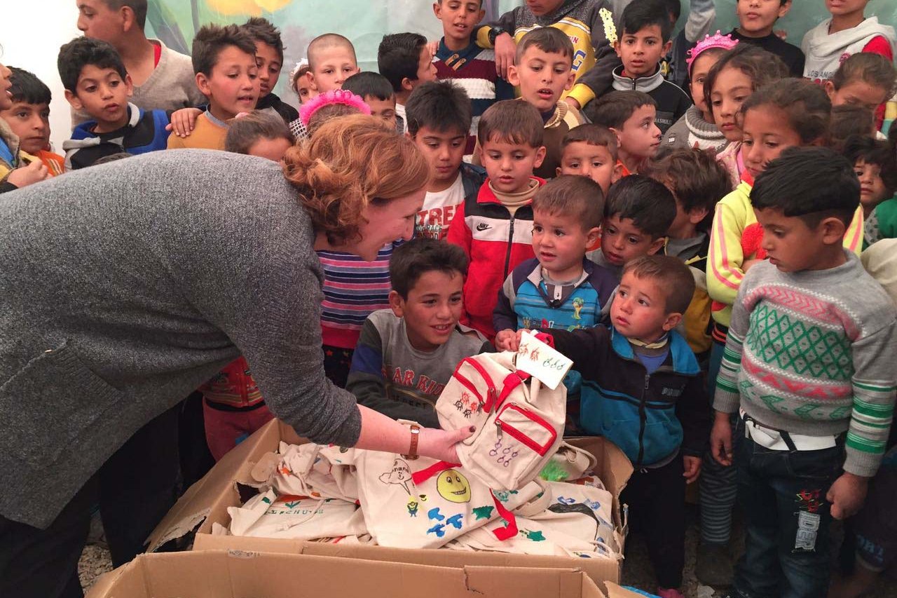 Jacqueline Flory verteilt Rucksäcke in Zeltschule